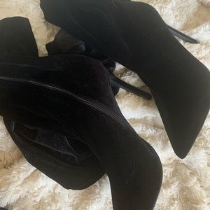 Black pointy velvet heeled knee high boots.